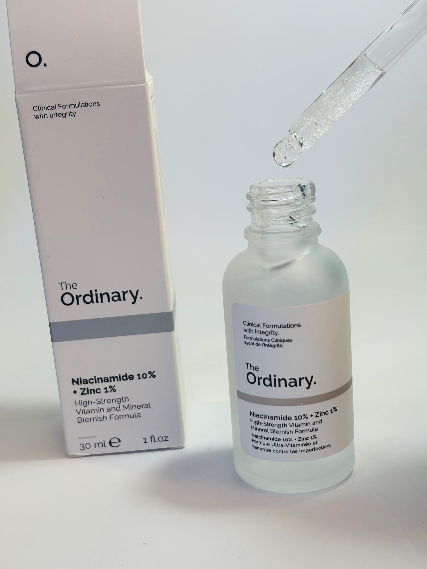 The Ordinary Niacinamide 30ml bottle front view
Close-up of Niacinamide Serum dropper with liquid
The Ordinary Niacinamide 10% + Zinc 1% packaging box with bottle
Bottle lying flat on light background with label visible
Lifestyle shot: serum bottle on vanity with plants or minimal decor
Texture close-up: drop of Niacinamide serum on hand or surface