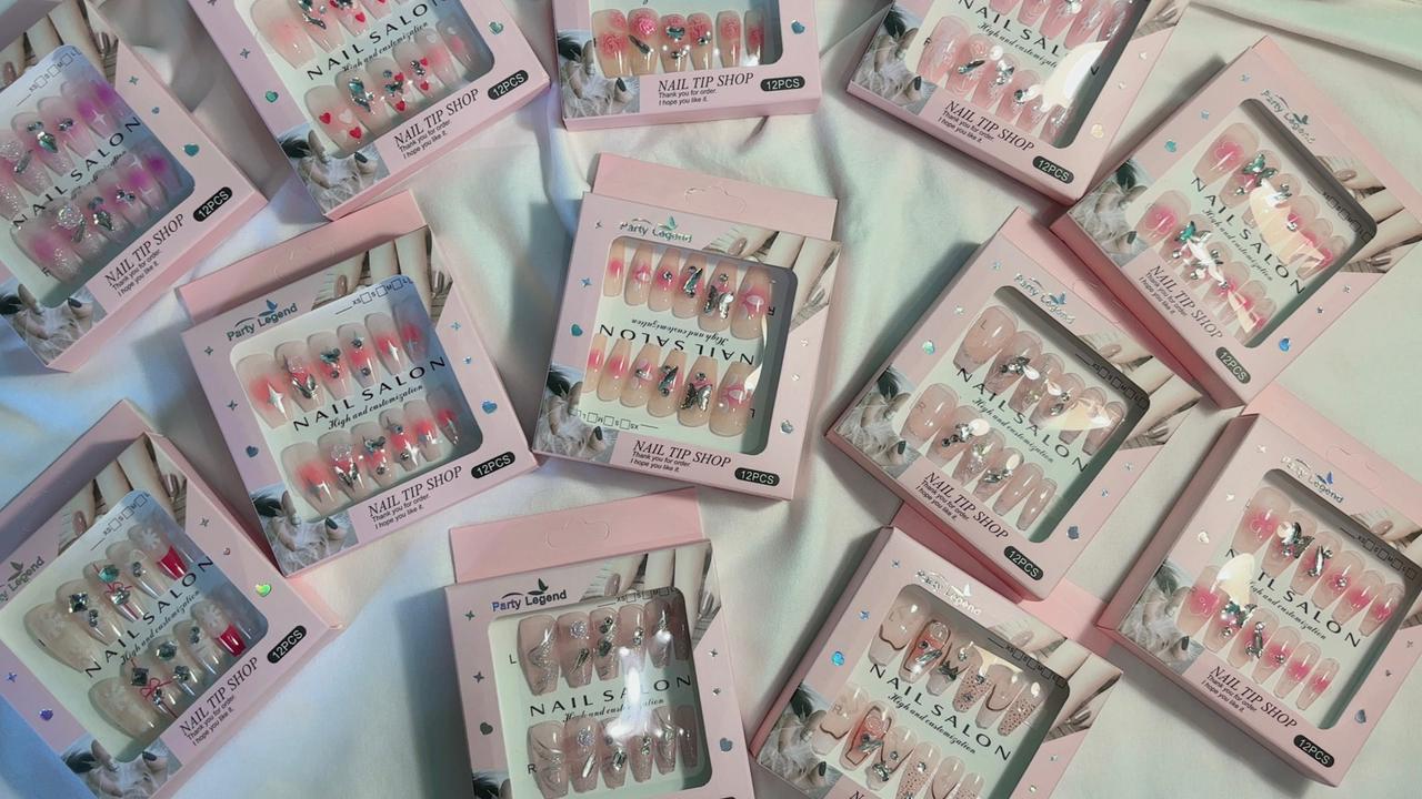 Amora Premium Press-On Fake Nails set box front view
Close-up of press-on nails decorative designs in packaging
Press-on nails box with pink border and branding visible
Display of nail tips floral & rhinestone designs in set
Press-on nails packaging on light background showing full set
Box of artificial nail tips with bold designs close-up
Press-on nail set styled in packaging “Nail Salon” view