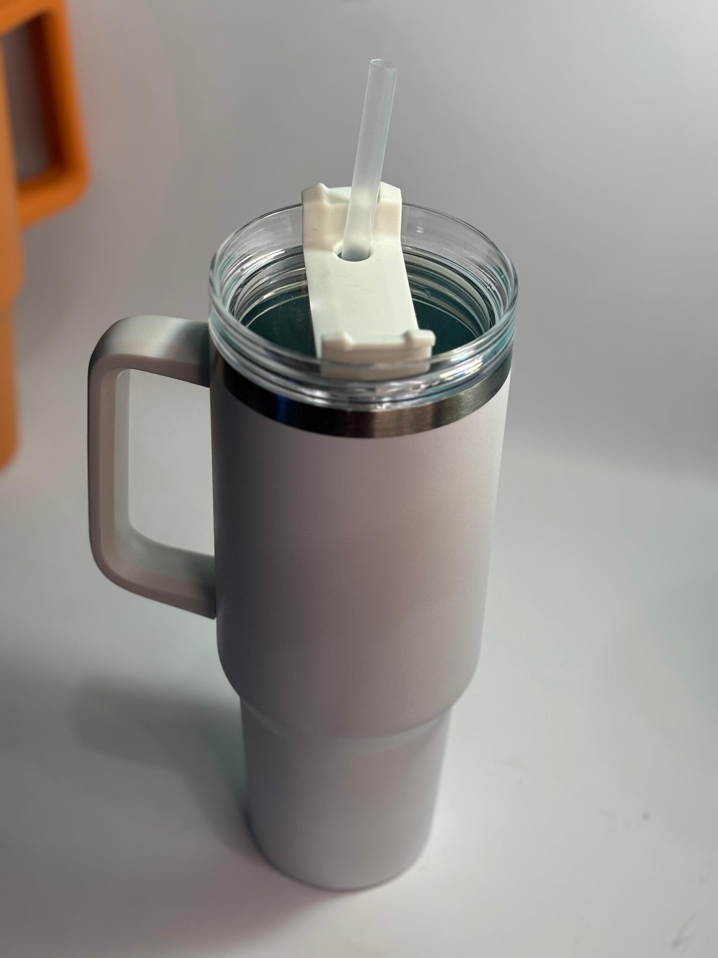 White insulated mug with handle and straw on a light gray background 40 oz stainless steel tumbler with straw and handle – leakproof insulated water bottle