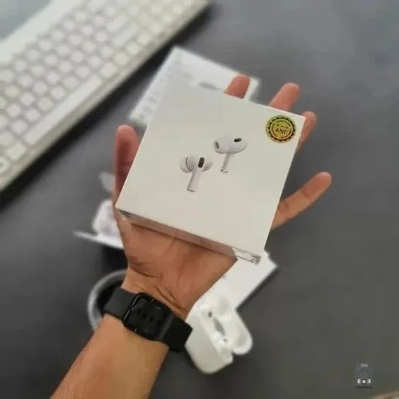 Hand holding a white box with earbud illustration on a desk with keyboard and mouse.