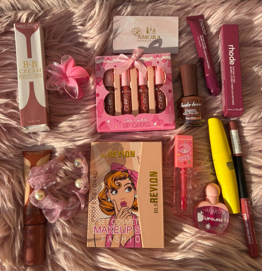 Flat-lay display of assorted beauty products including BB cream, lip gloss sets, mascara, nail polish, lipstick, scrunchies, and a makeup palette arranged on a pink fluffy background.