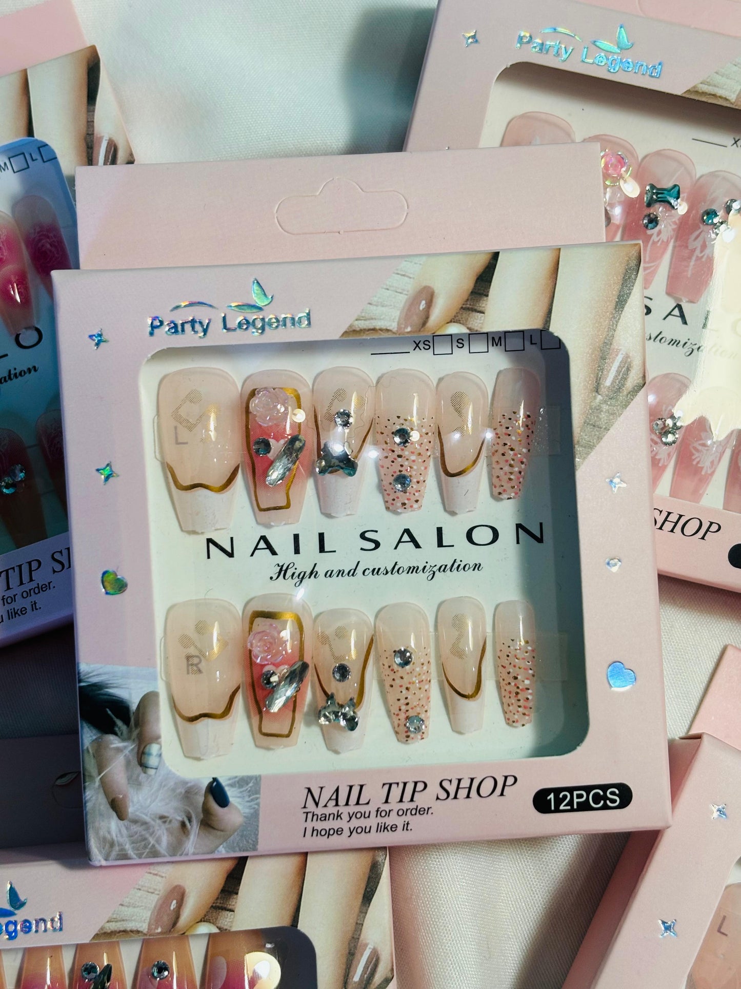 Amora Premium Press-On Fake Nails set box front view

Close-up of press-on nails decorative designs in packaging

Press-on nails box with pink border and branding visible

Display of nail tips floral & rhinestone designs in set

Press-on nails packaging on light background showing full set

Box of artificial nail tips with bold designs close-up

Press-on nail set styled in packaging “Nail Salon” view