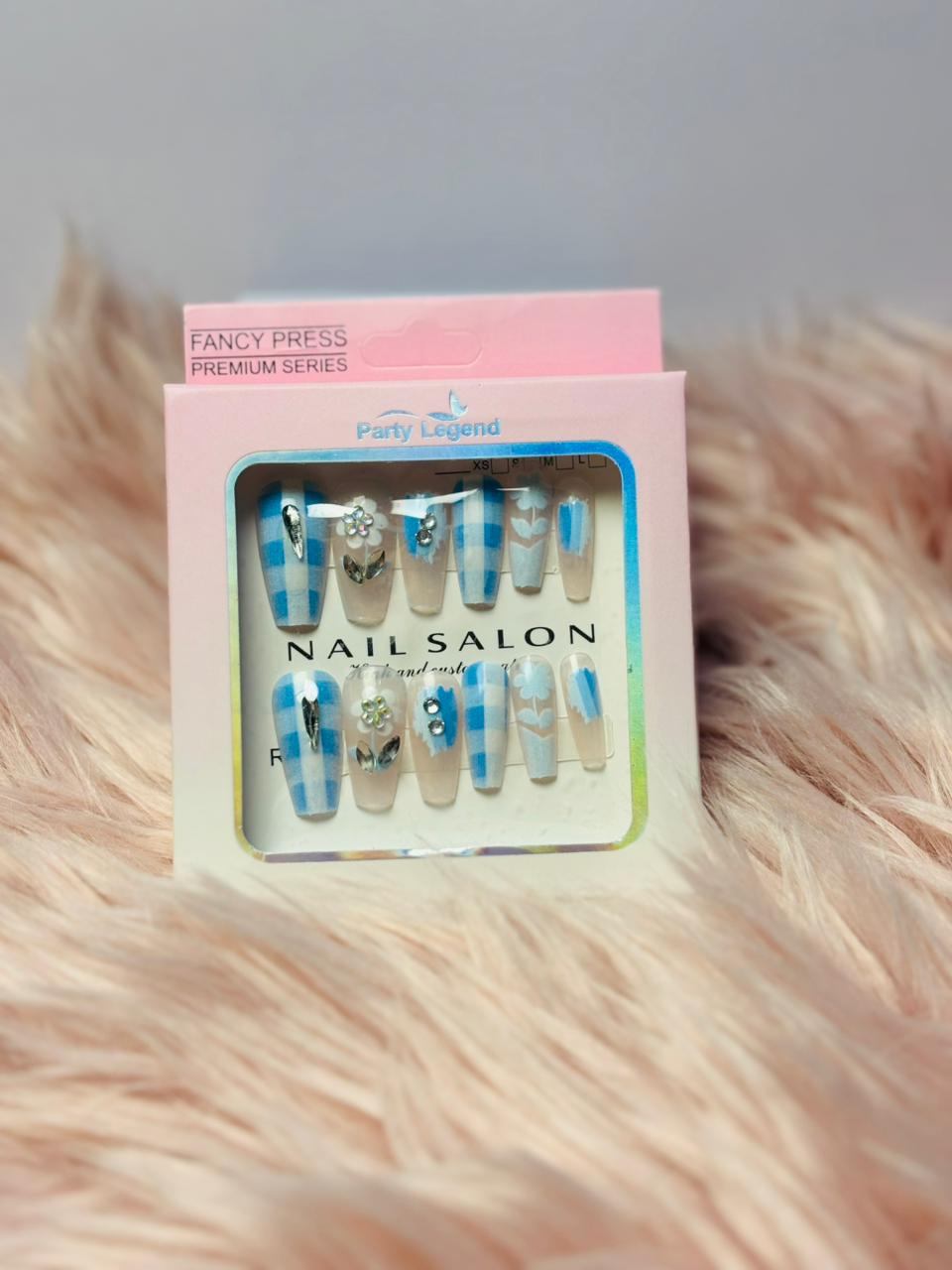 Elegant blue beaded press-on nails with floral accents on a white base, premium salon design by Amora Mega Store.
