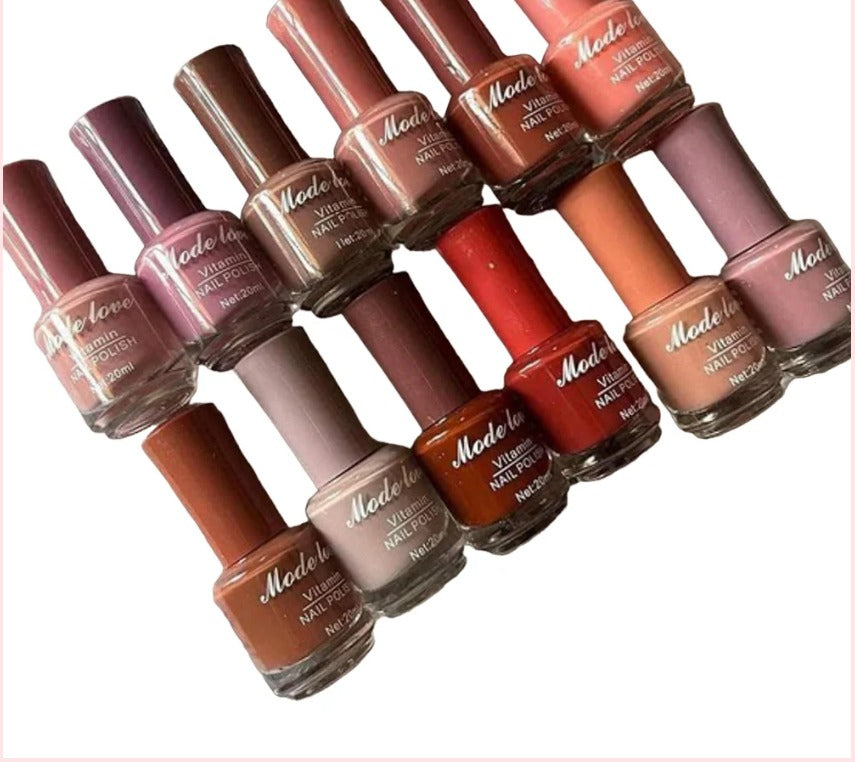  Multiple “Mode Love Vitamin Nail Polish” bottles displayed in shades of pink, nude, brown, and red tones arranged diagonally on a white surface.

