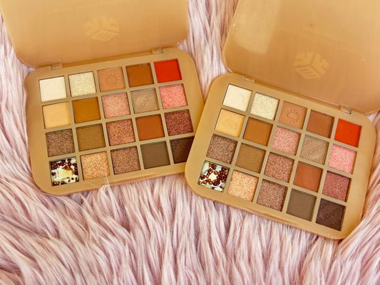 Makeup palette with various colors on a pink fur background