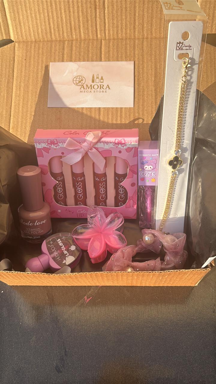Close-up shot of a pink-themed beauty surprise box showing lip products, nail items, and decorative packaging.