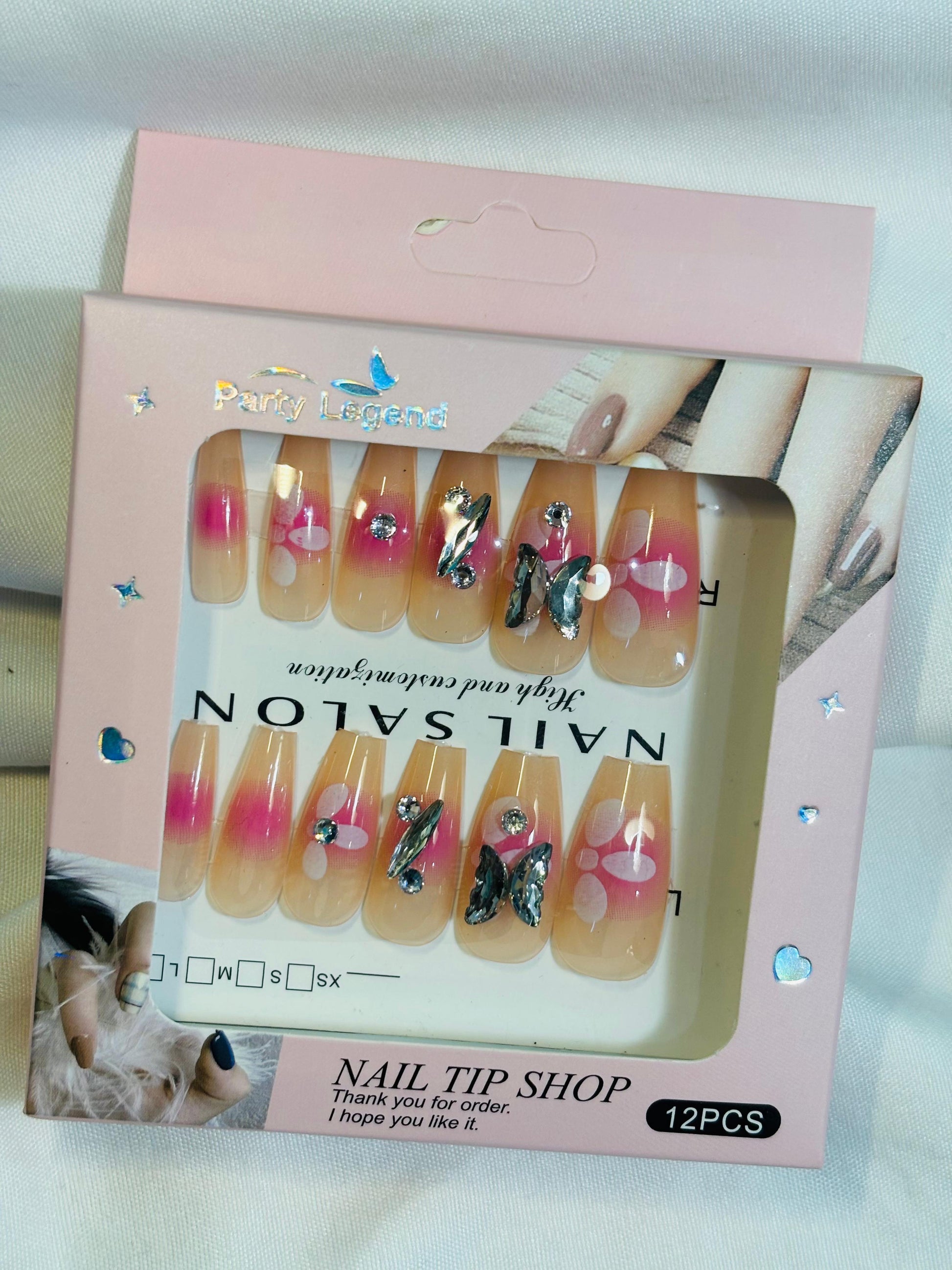 Amora Premium Press-On Fake Nails set box front view

Close-up of press-on nails decorative designs in packaging

Press-on nails box with pink border and branding visible

Display of nail tips floral & rhinestone designs in set

Press-on nails packaging on light background showing full set

Box of artificial nail tips with bold designs close-up

Press-on nail set styled in packaging “Nail Salon” view