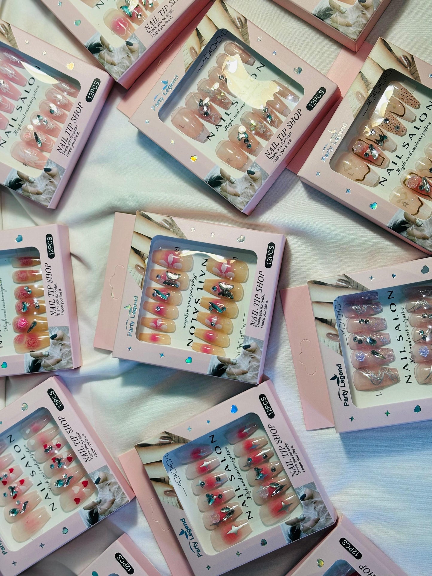 Amora Premium Press-On Fake Nails set box front view

Close-up of press-on nails decorative designs in packaging

Press-on nails box with pink border and branding visible

Display of nail tips floral & rhinestone designs in set

Press-on nails packaging on light background showing full set

Box of artificial nail tips with bold designs close-up

Press-on nail set styled in packaging “Nail Salon” view