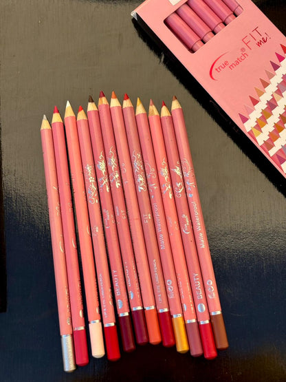 Unboxed True Match Fit Me pencil sets arranged neatly with all pencils displayed beside their open packaging on a polished black background.
