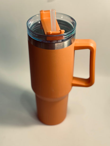 Orange travel mug with a handle on a light gray background 40 oz stainless steel tumbler with straw and handle – leakproof insulated water bottle
