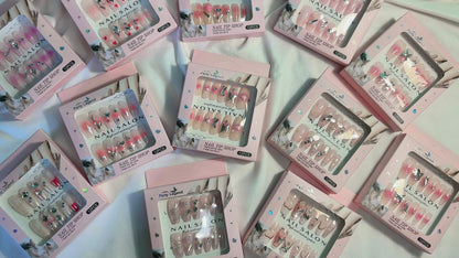 Amora Premium Press-On Fake Nails set box front view

Close-up of press-on nails decorative designs in packaging

Press-on nails box with pink border and branding visible

Display of nail tips floral & rhinestone designs in set

Press-on nails packaging on light background showing full set

Box of artificial nail tips with bold designs close-up

Press-on nail set styled in packaging “Nail Salon” view