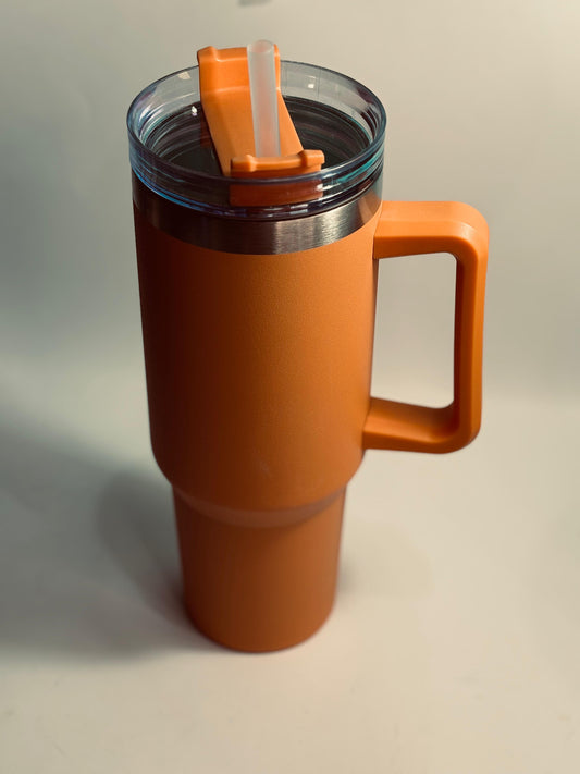 Orange travel mug with a handle and straw on a light gray background