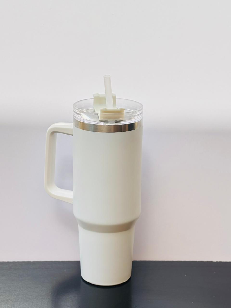 White matte insulated tumbler cup with a handle and clear straw placed on a clean, minimal background