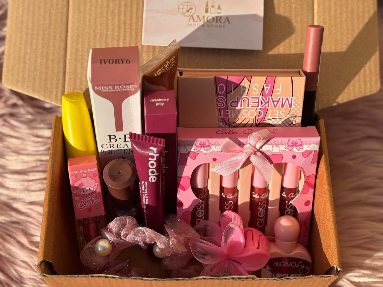 All-in-One Beauty Gift Box opened and displayed with a black ribbon lid, showcasing organized makeup products including glosses, BB cream, scrunchies, lip products, and a makeup palette.
