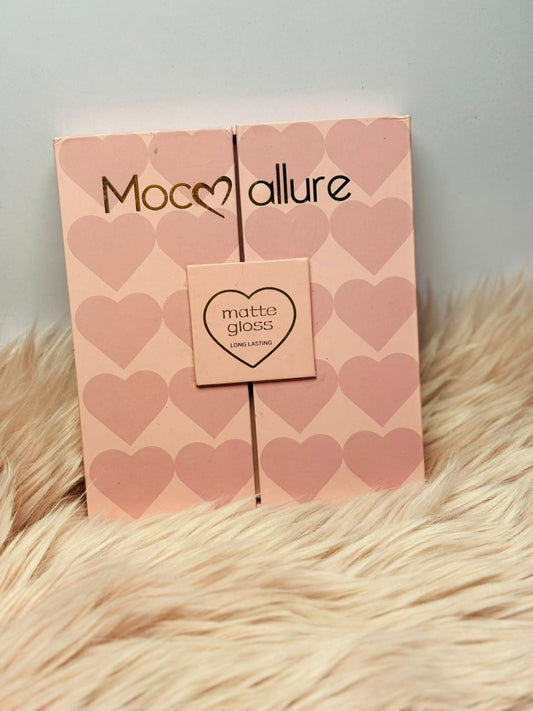 Pink Mocallure matte and gloss lipstick gift box with heart design placed on soft fur background.