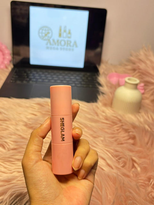 SHEGLAM soft pink liquid blush held in a hand with an Amora Mega Store screen in the background.