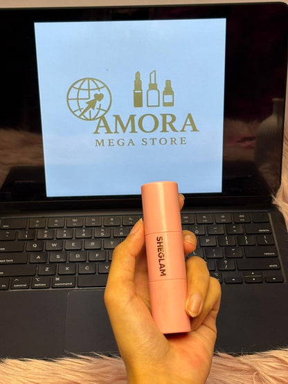 SHEGLAM soft pink liquid blush standing in front of a laptop displaying Amora Mega Store.